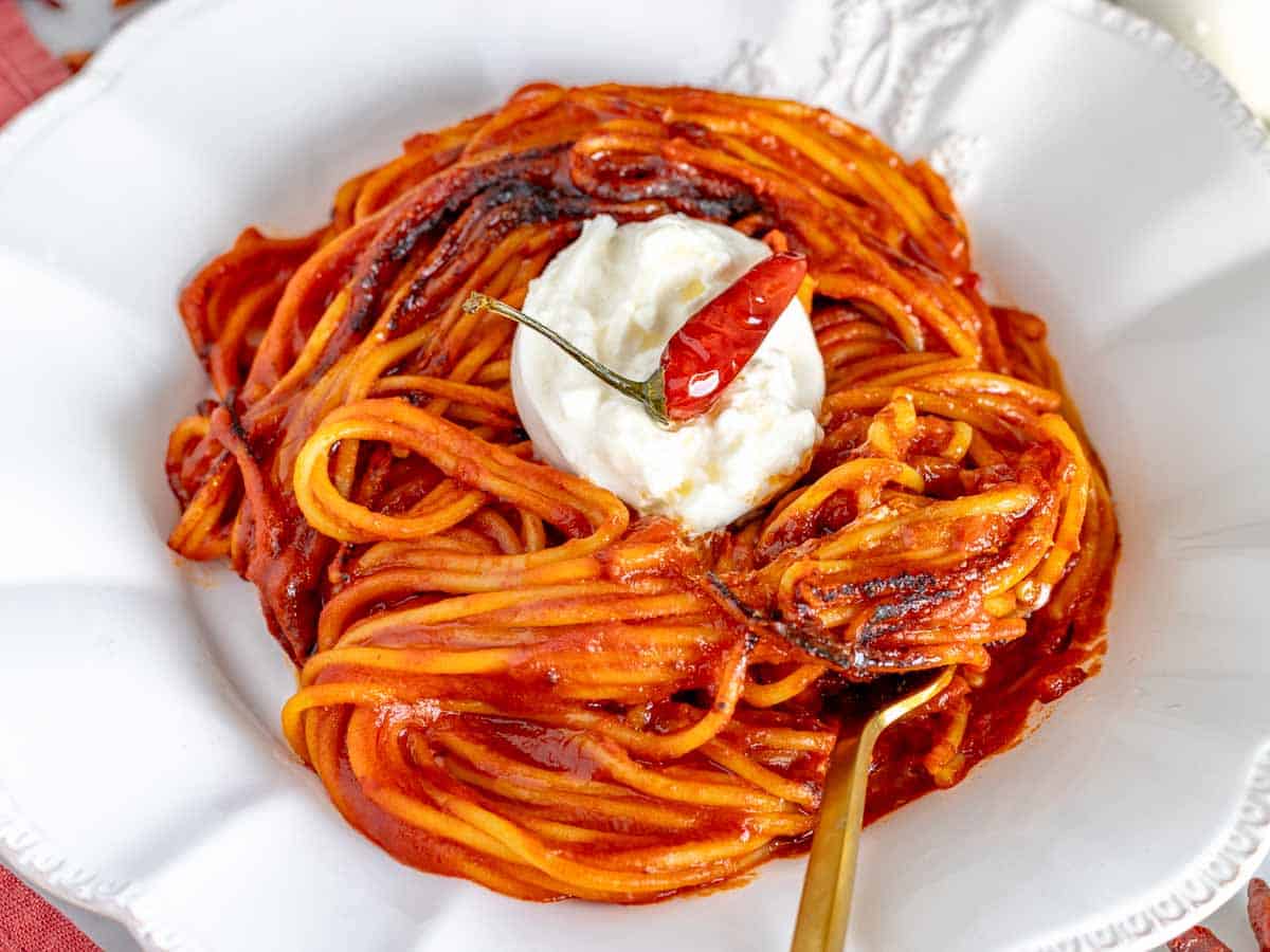 spaghetti all'assassina topped with burrata