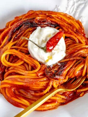 pasta all assassina with a fork, burrata cheese, and a chili