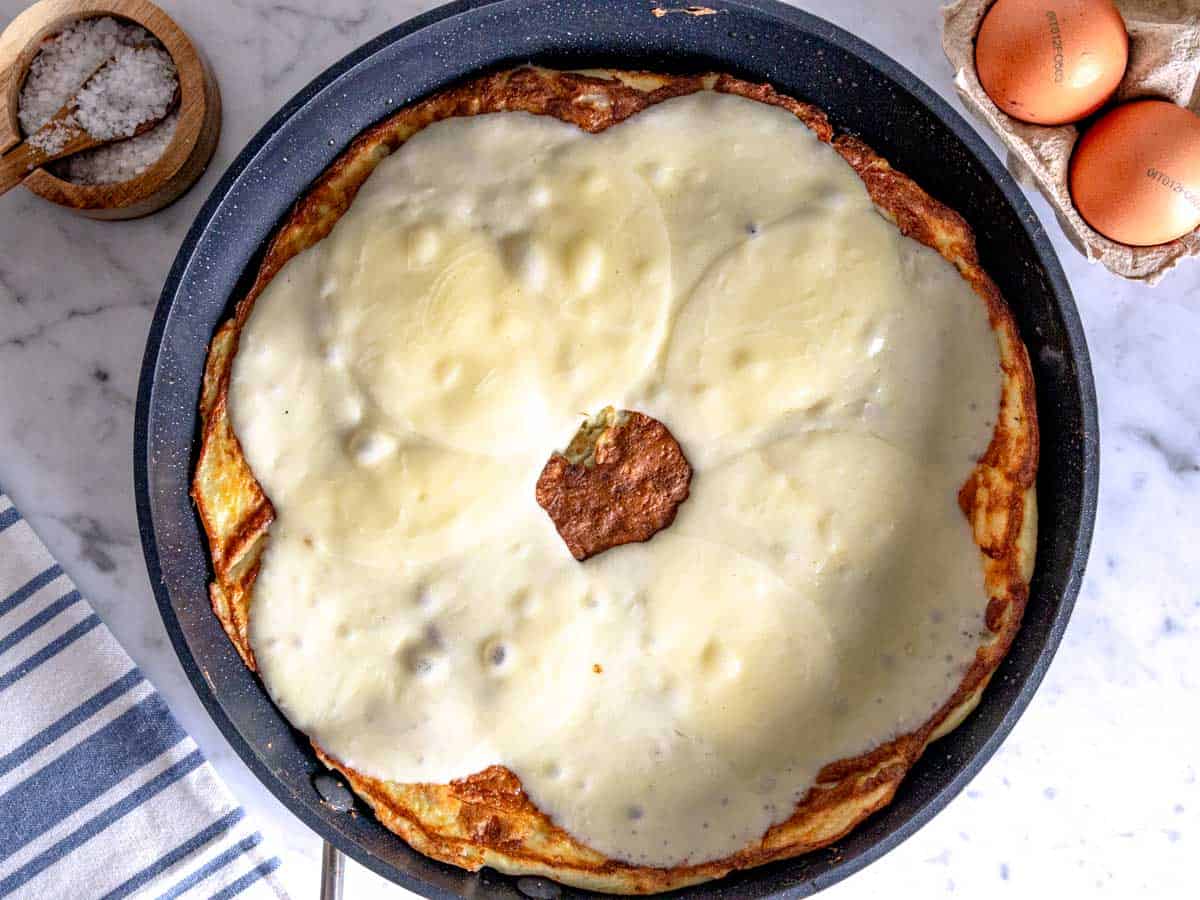 Frittata with melted provolone cheese in a skillet