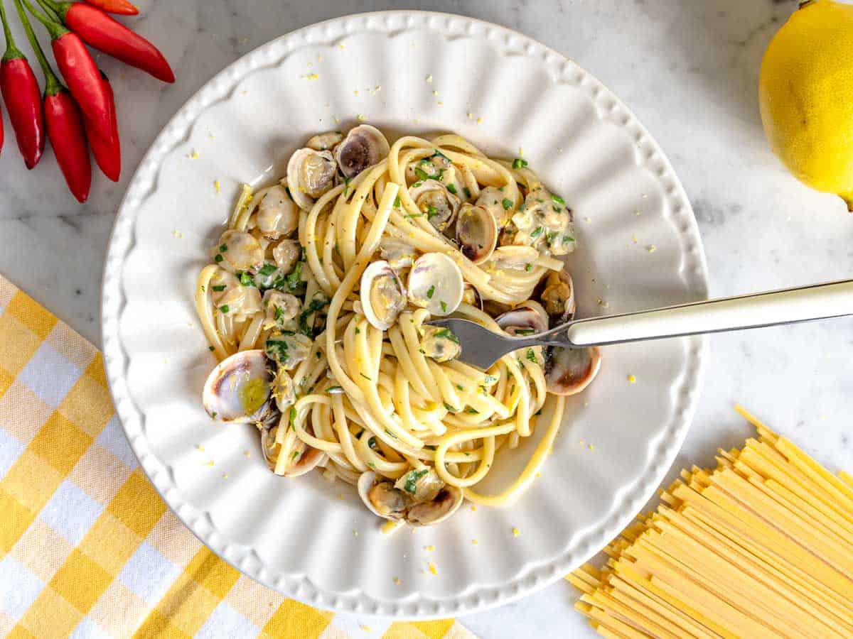 Linguine with clams on a white plate with a fork