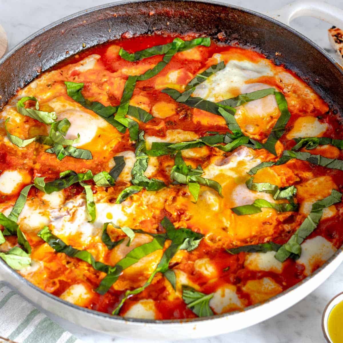 eggs in purgatory in a shite skillet with basil