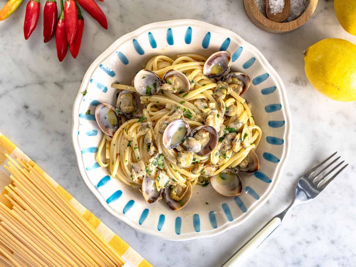 Linguine with clam sauce in a blue handmade plate.