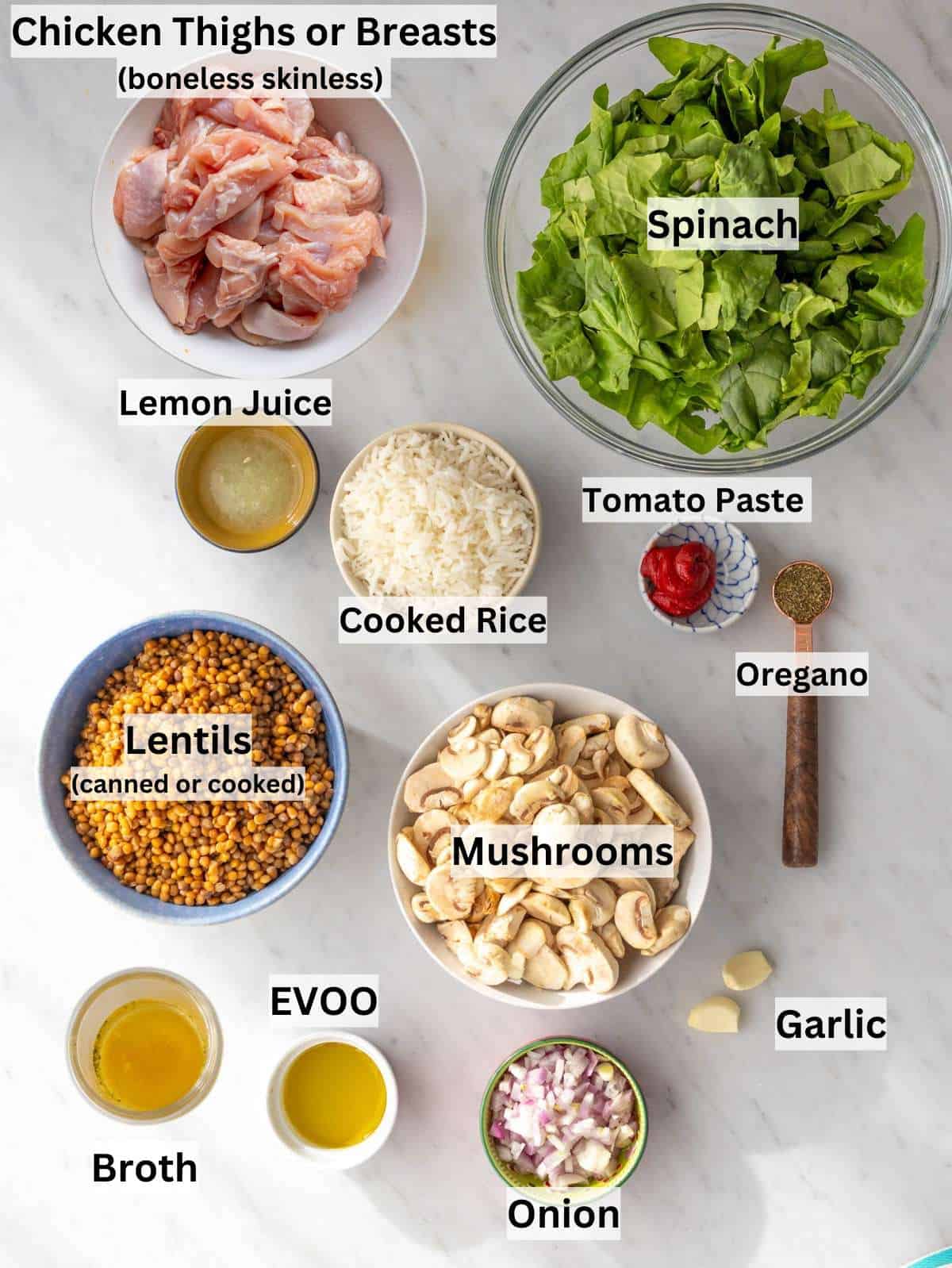 Ingredients shot Mediterranean chicken lentils rice veggies and sauce ingredients arranged on a board.