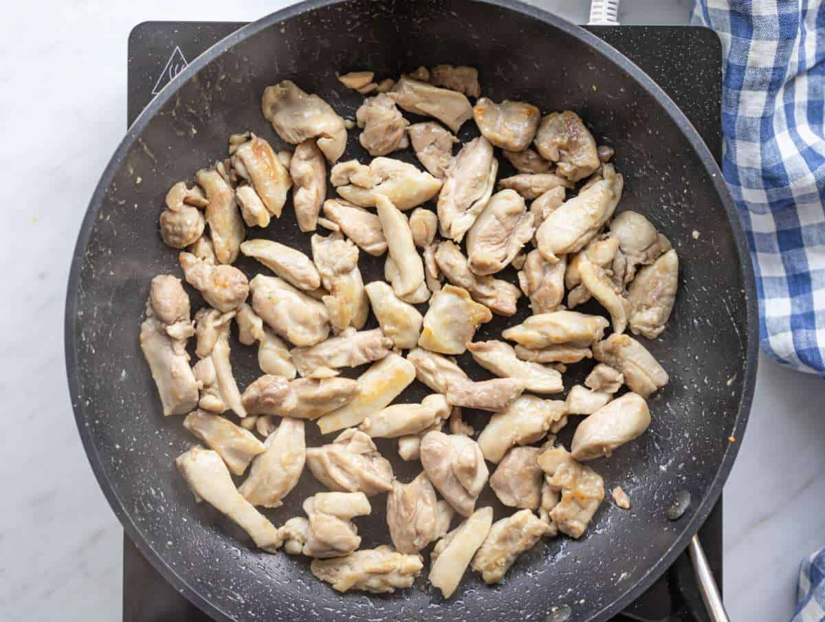 Step 2 cooking chicken sautéing seasoned chicken pieces until golden in a skillet.