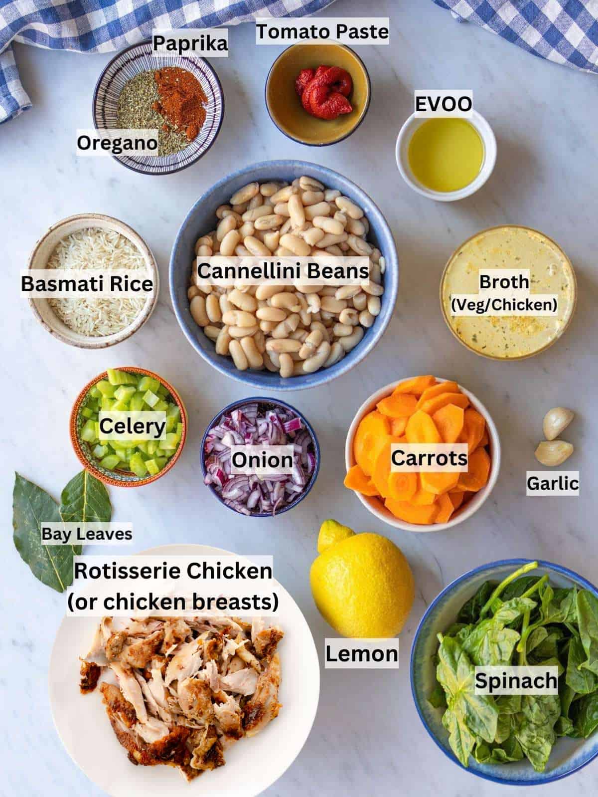 All ingredients for Greek chicken and bean stew arranged on a kitchen counter for cooking.