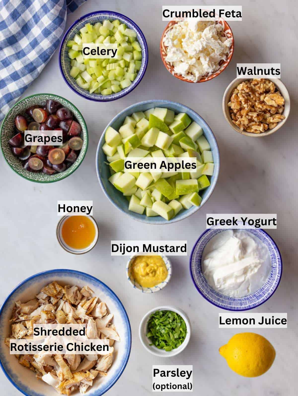 Chicken Waldorf Salad ingredients arranged with apples grapes yogurt celery nuts and chicken.