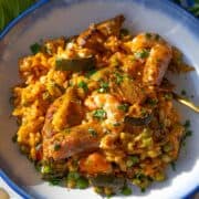 Shrimp paella cooked on a sheet pan with vegetables rice and served in a bowl.
