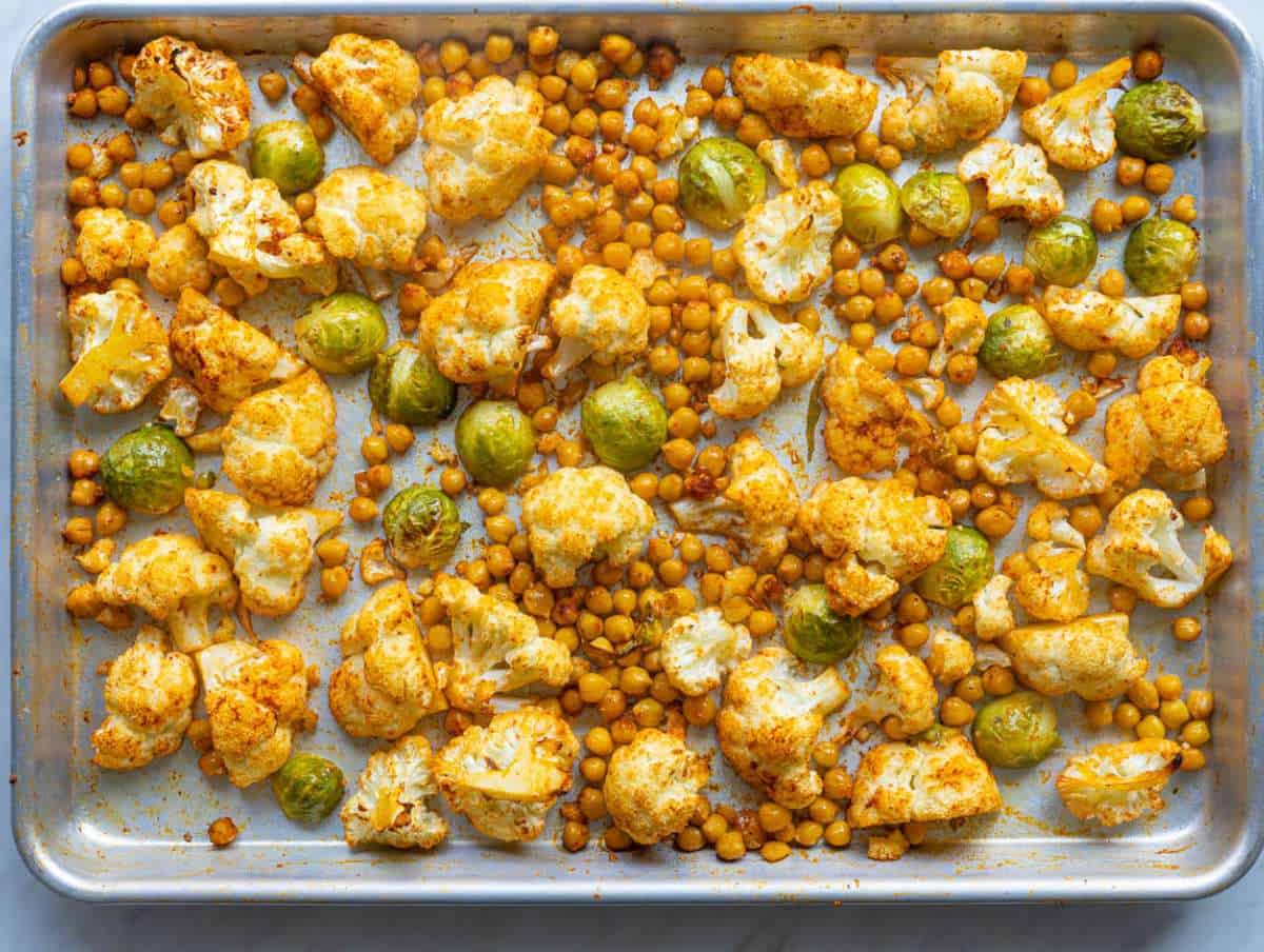 Step 1 Roasting cauliflower and chickpeas on sheet pan for salmon orzo recipe.