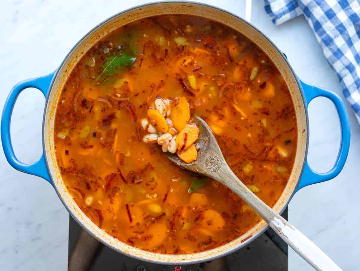 Step 2 Adding beans broth and spices to the pot for the Mediterranean stew.