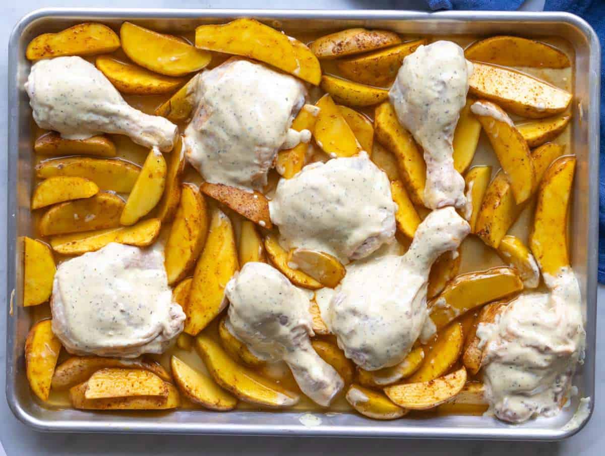 Step 3 Chicken pieces coated in lemon yogurt mixture placed between potatoes on sheet pan