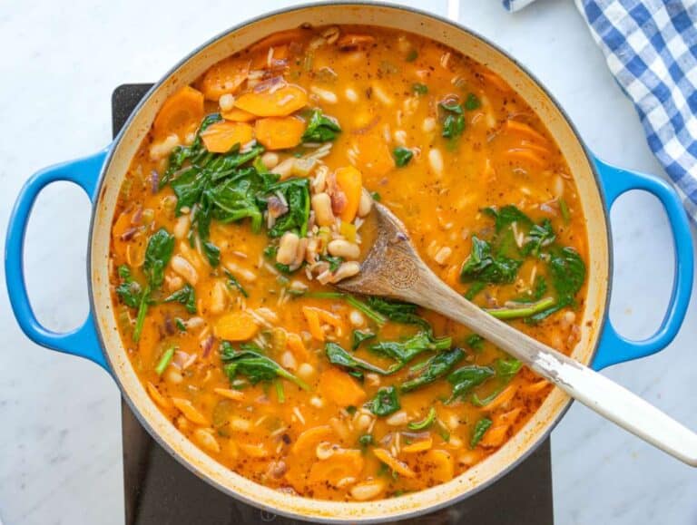 Step 4 Stirring fresh spinach into the pot to wilt into the hot stew.