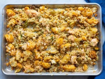 Step 4 Tossing cooked orzo with salmon and roasted vegetables on sheet pan.