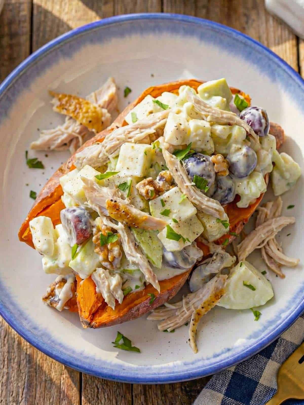 Top down Chicken Waldorf Salad served on a microwaved sweet potato showing crunchy apples grapes celery and shredded chicken.