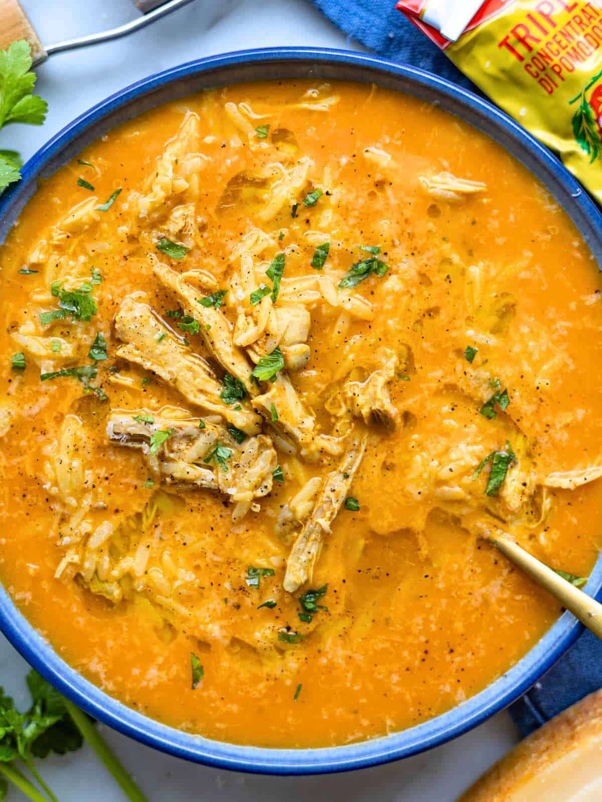 Bowl of Italian penicillin soup with orzo, chicken, parsley, Parmesan, and olive oil.