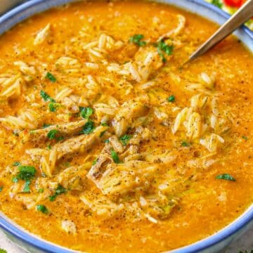 Cozy bowl of Italian penicillin soup on rustic table with spoon and olive oil.