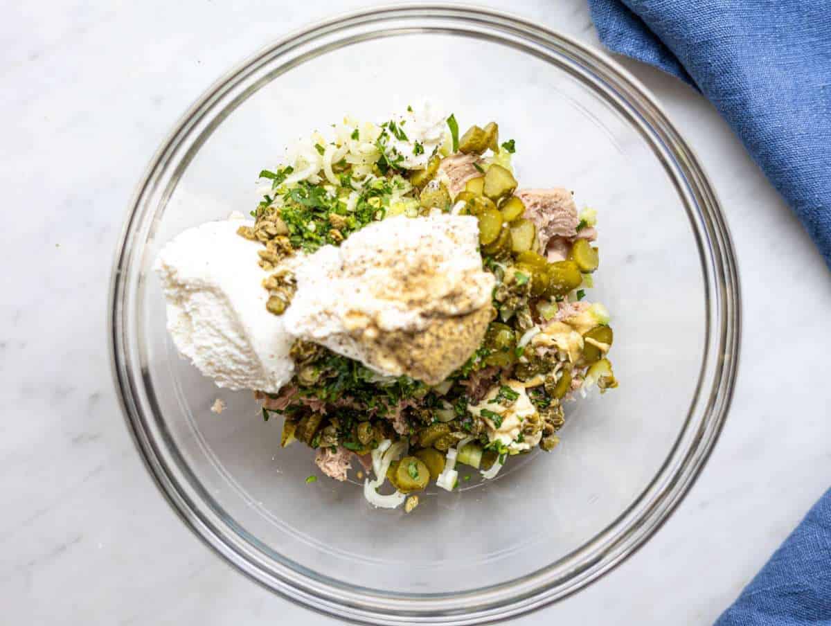 Step 2 Chopped eggs, celery, pickles, and herbs added to tuna in a mixing bowl.