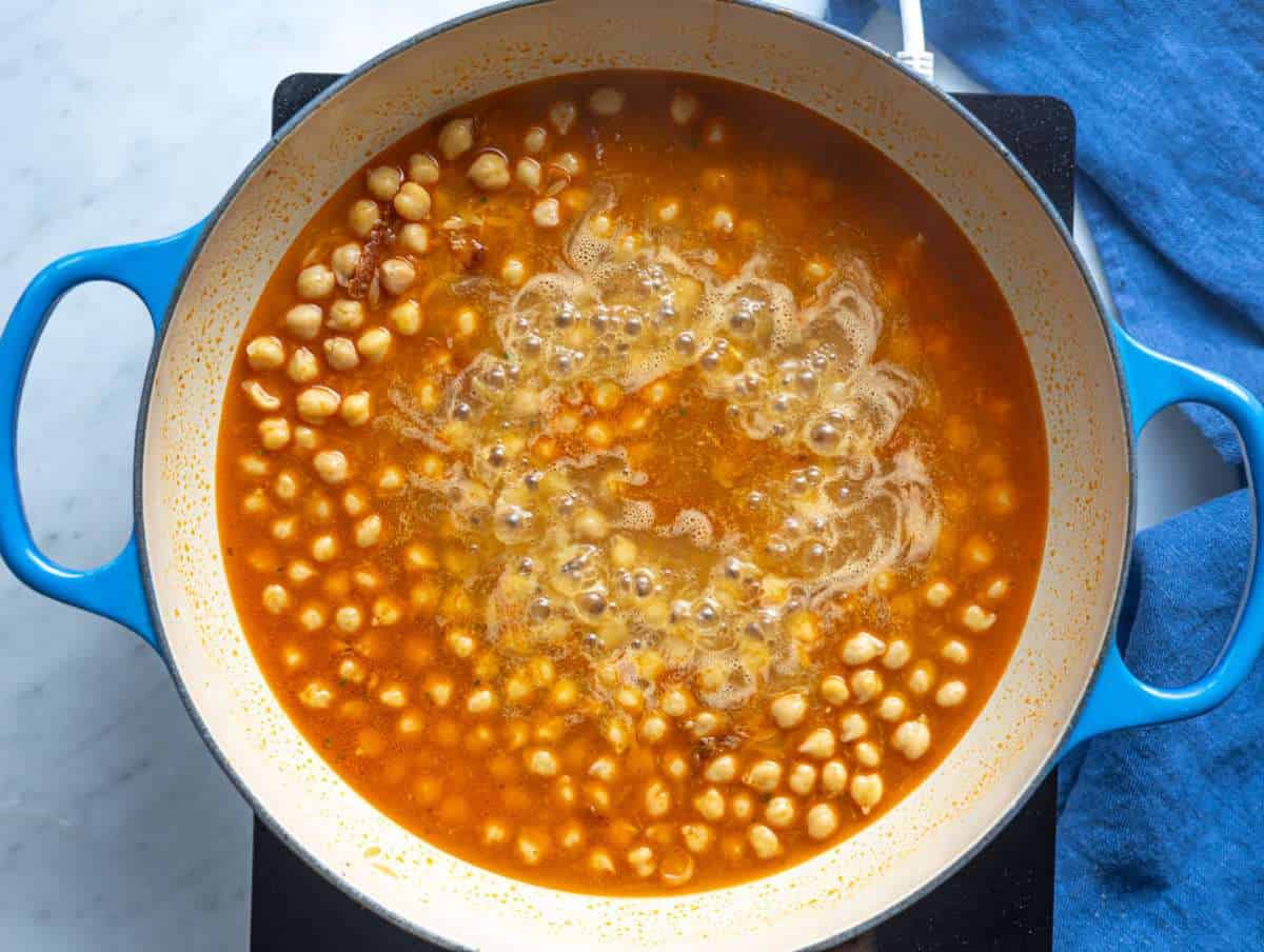 Step 2 Orzo and garlic stirred in the pan with broth and chickpeas.