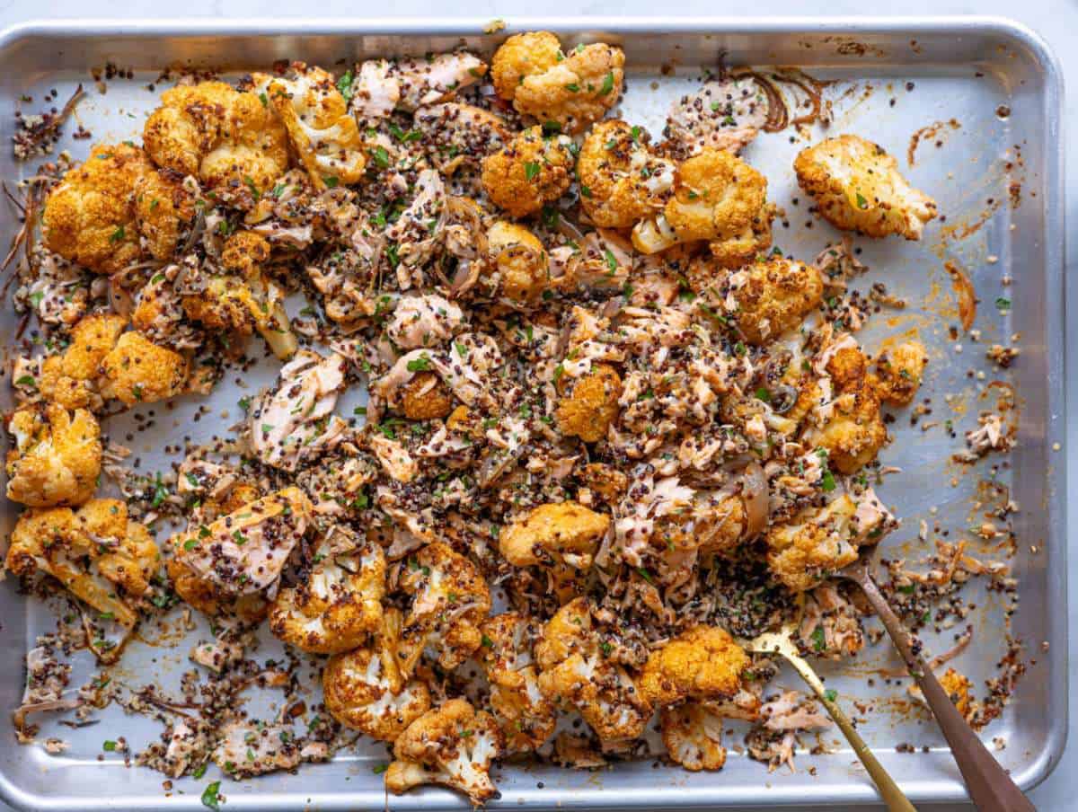 Step 4 Tossing flaked salmon, roasted vegetables, and quinoa together on the sheet pan.