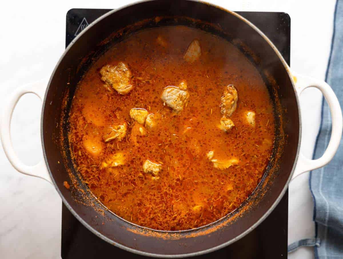 Step 2 Chicken added to boiling broth with herbs simmering gently.