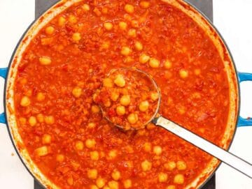 Step 2 Chickpeas and crushed tomatoes simmering in a pot of chicken broth.