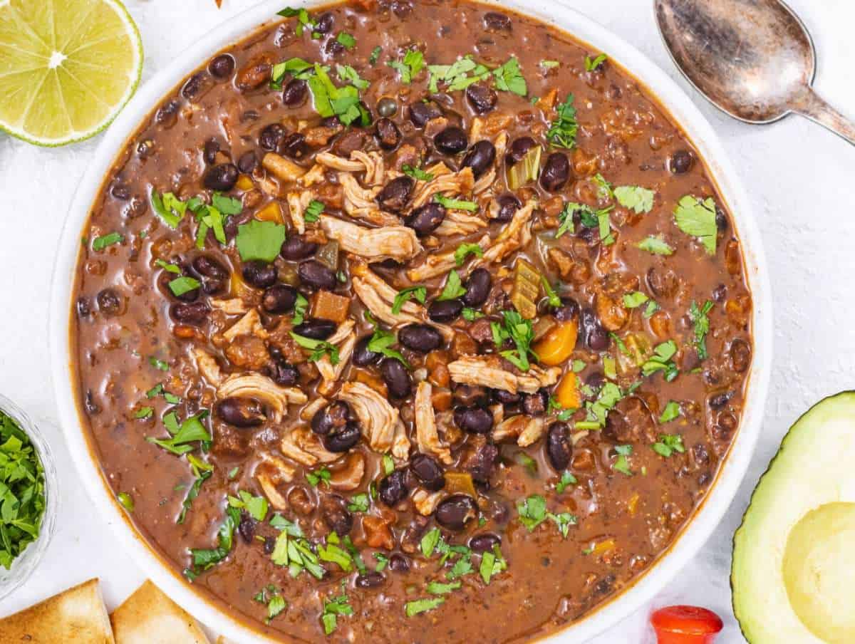 Step 4 Bowl of black bean chicken soup topped with cilantro and lime wedge.