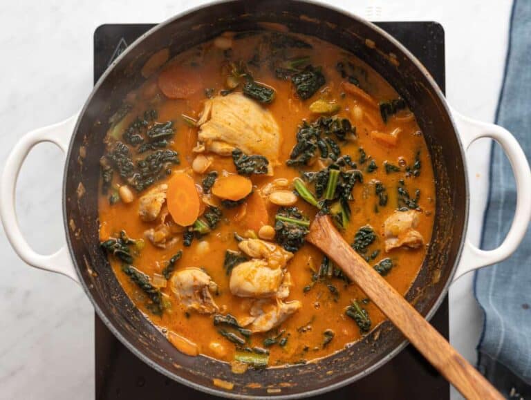 Step 4 Kale and whole white beans stirred into the simmering soup.