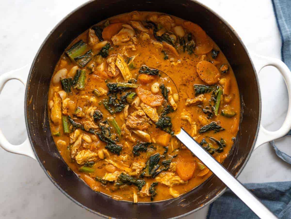 Step 6 Shredded chicken being returned to the pot and stirred into the soup.