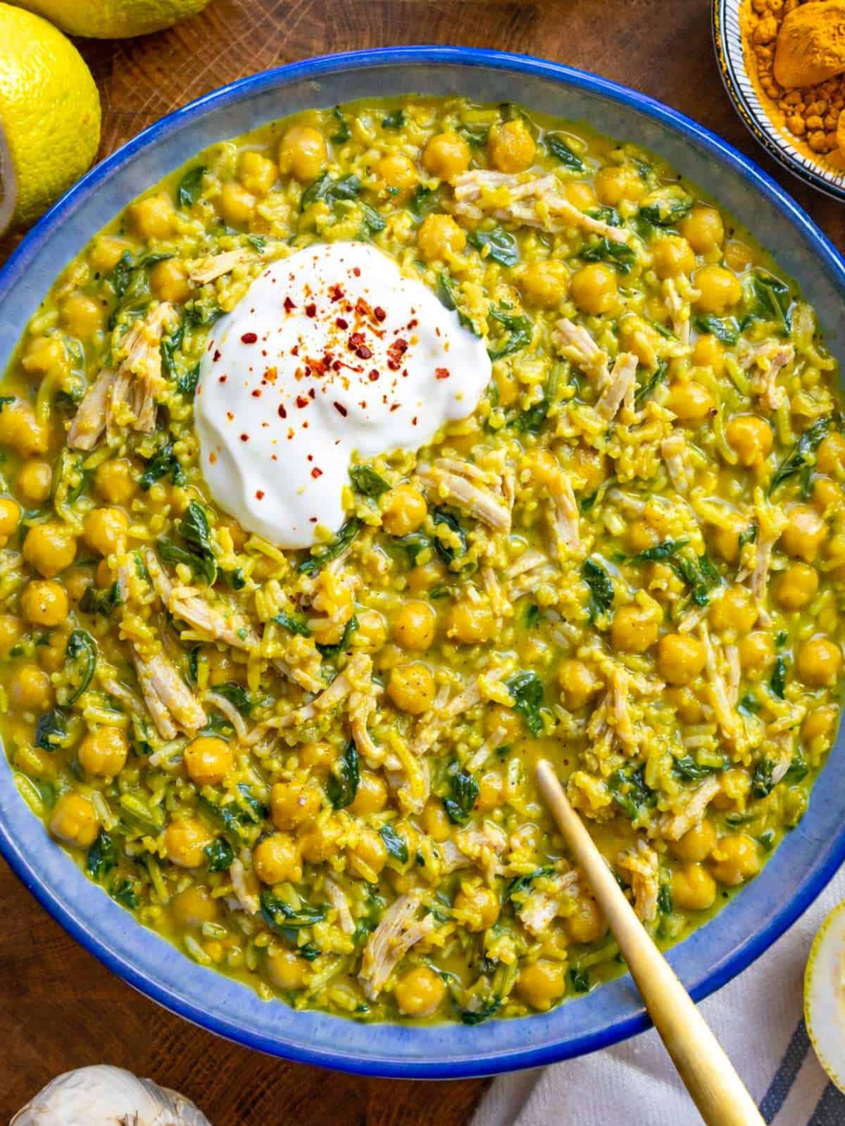 Turmeric chicken and rice in skillet with spinach and chickpeas.