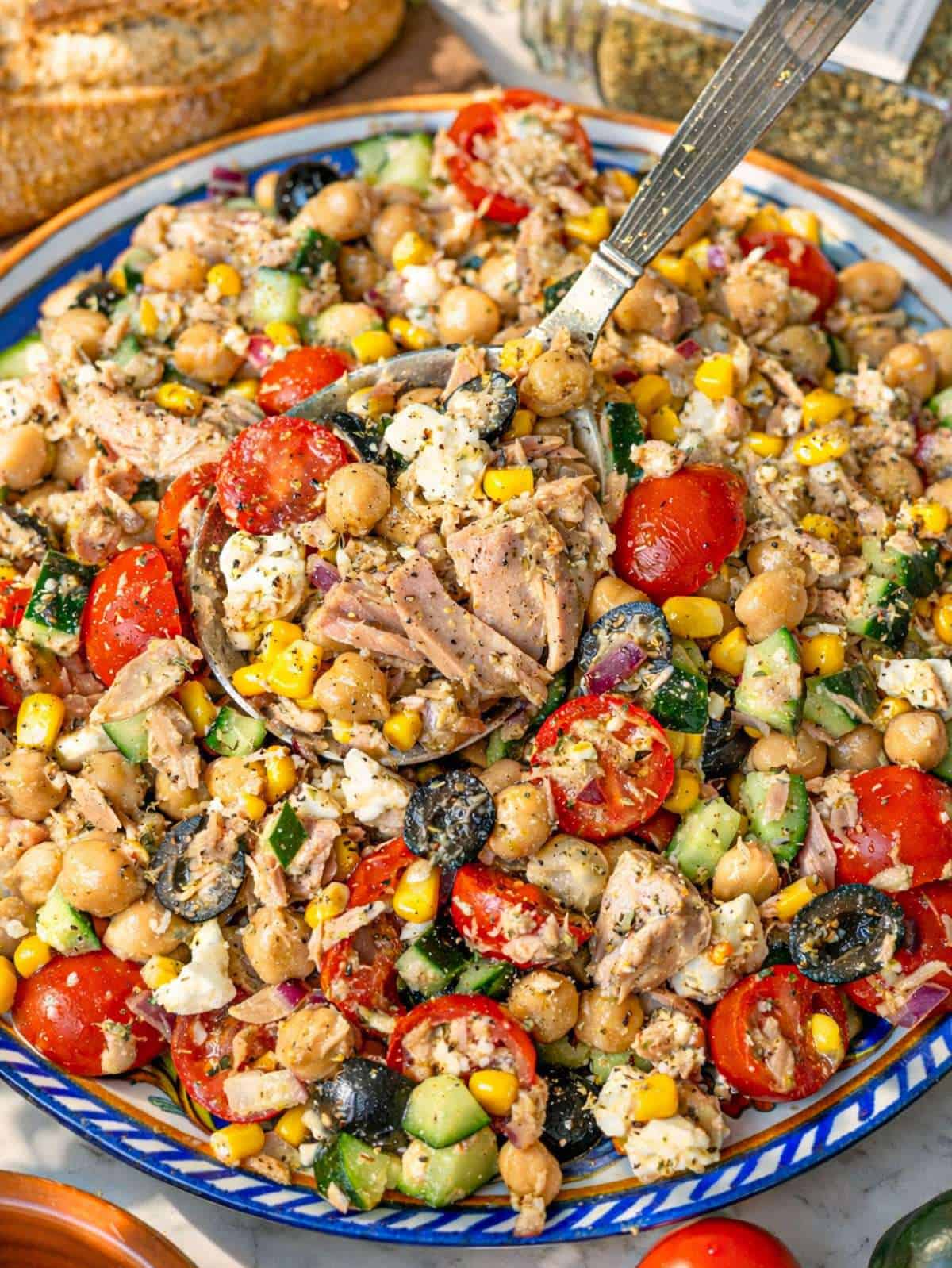 Close up of tuna chickpea salad with flaky tuna chickpeas feta and fresh herbs.