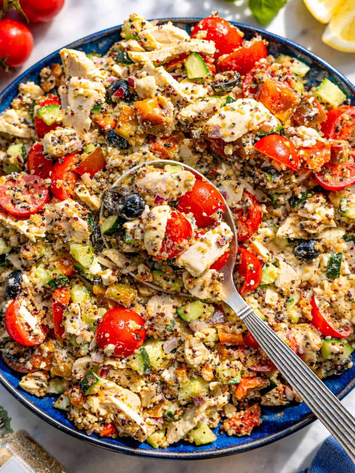 Large serving bowl of Mediterranean Chicken Quinoa Salad in natural window light.