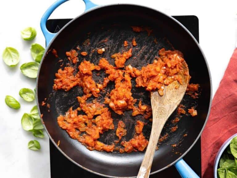 Step 1 Onion cooking in olive oil with tomato paste and garlic in skillet.