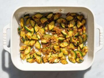 Step 1 Sautéed zucchini and red onions arranged in a baking pan on parchment.