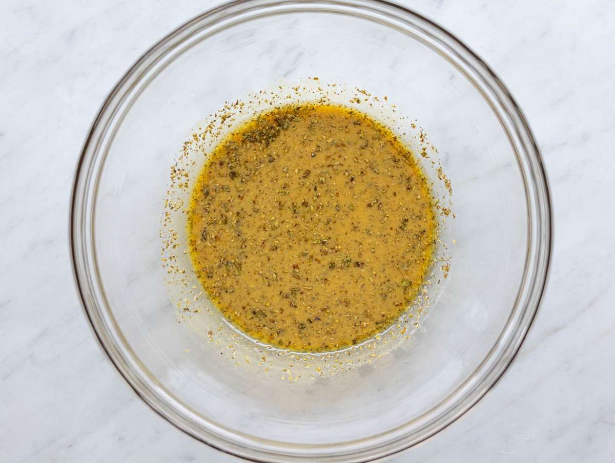 Step 1 Whisking olive oil vinegar mustard oregano and honey in bowl to make salad dressing.