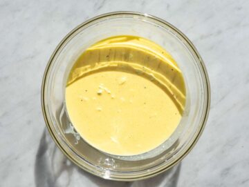 Step 2 A smooth and creamy mixture of whisked eggs and Greek yogurt in a glass bowl.