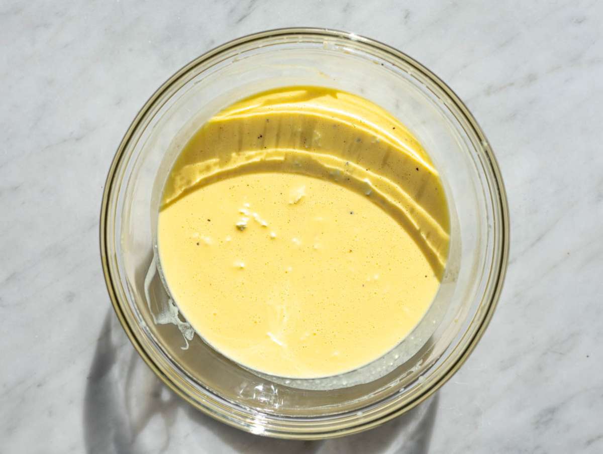 Step 2 A smooth and creamy mixture of whisked eggs and Greek yogurt in a glass bowl.