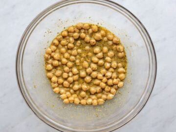 Step 2 Chickpeas soaking in olive oil mustard dressing in a bowl.