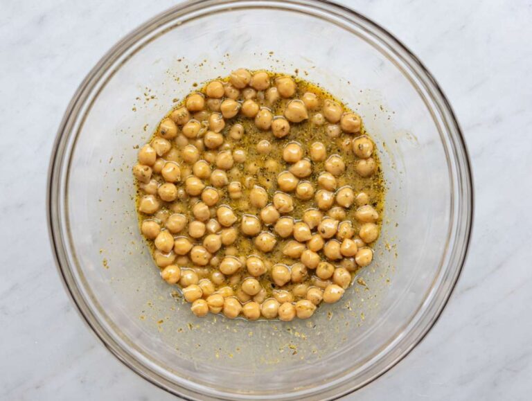 Step 2 Chickpeas soaking in olive oil mustard dressing in a bowl.