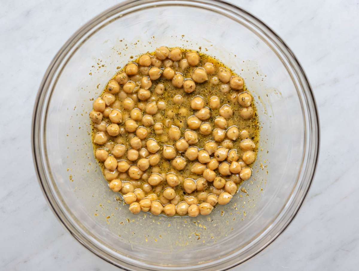 Step 2 Chickpeas soaking in olive oil mustard dressing in a bowl.