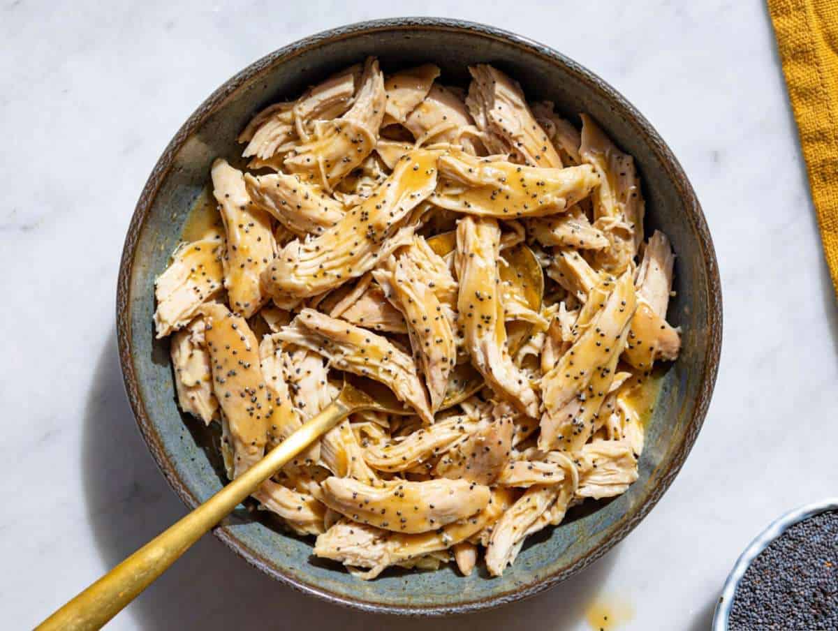 Step 2 Tossing shredded chicken with balsamic dressing in a bowl.
