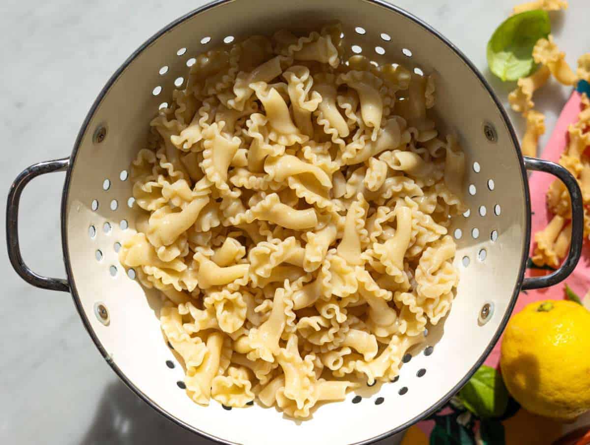 Step 3 Boiled pasta draining in a white colander.