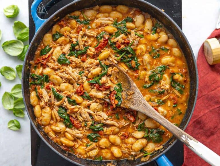 Step 3 Brothy chicken and beans simmering gently in skillet with spinach.