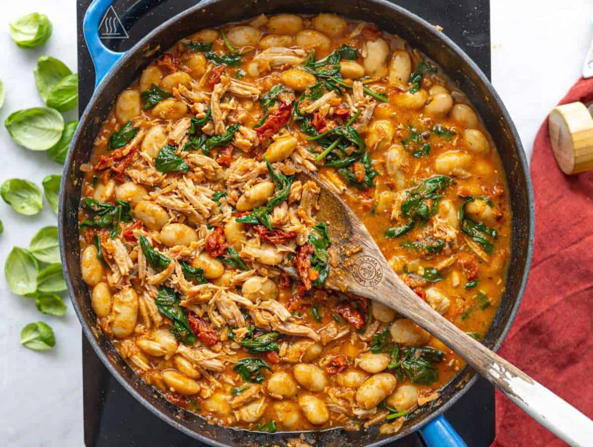 Step 3 Brothy chicken and beans simmering gently in skillet with spinach.