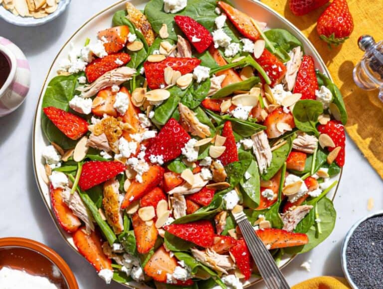 Step 3 Layering spinach, chicken, and strawberries on a large serving platter.