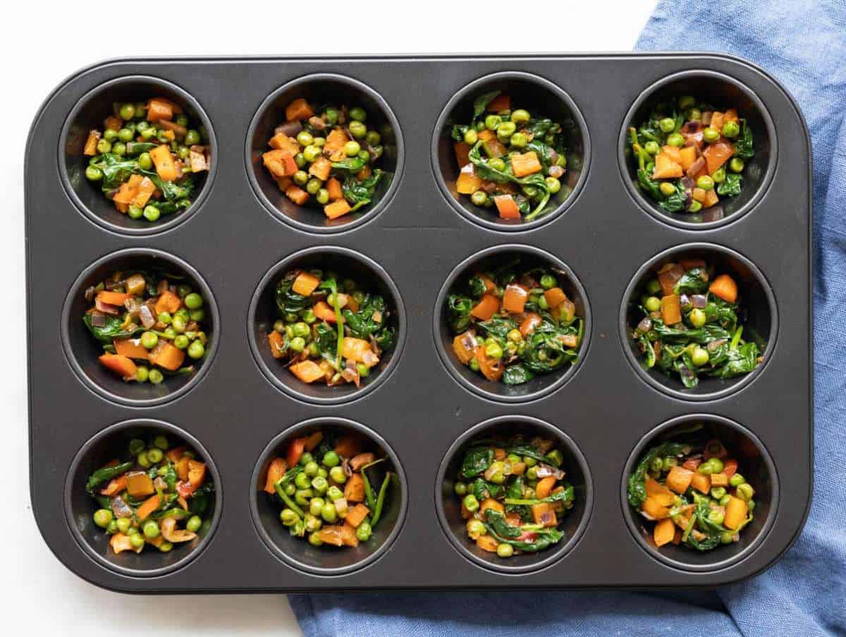 Step 3 Oiled muffin pan filled with sautéed vegetables.