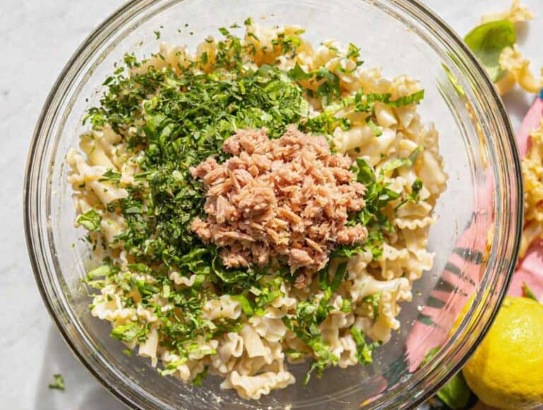 Step 4 Cooked pasta, tuna, and herbs being gently mixed in bowl.