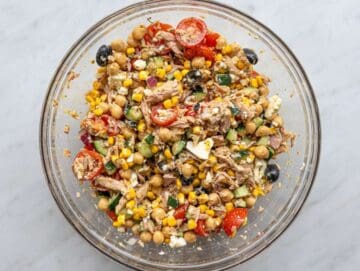 Step 4 Tossing tuna chickpea salad with marinated chickpeas and dressing in mixing bowl.
