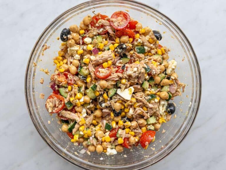 Step 4 Tossing tuna chickpea salad with marinated chickpeas and dressing in mixing bowl.