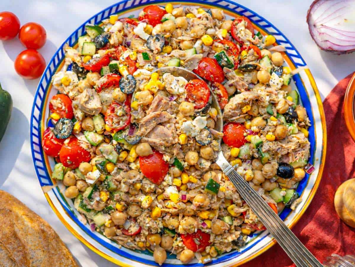 Step 5 Mediterranean tuna chickpea salad served on a platter with feta and fresh parsley.