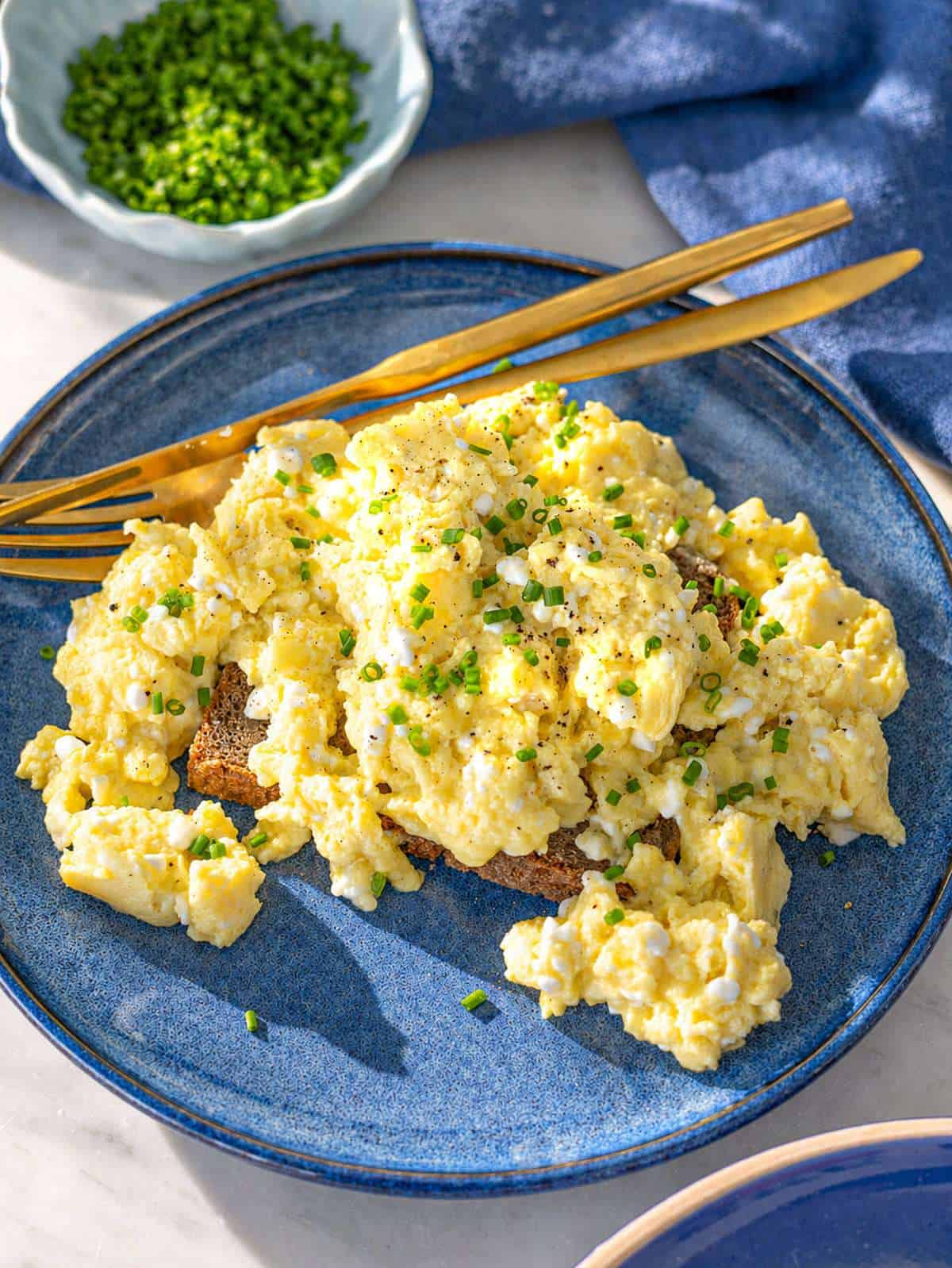 Close up of creamy cottage cheese eggs with soft curds and glossy texture.