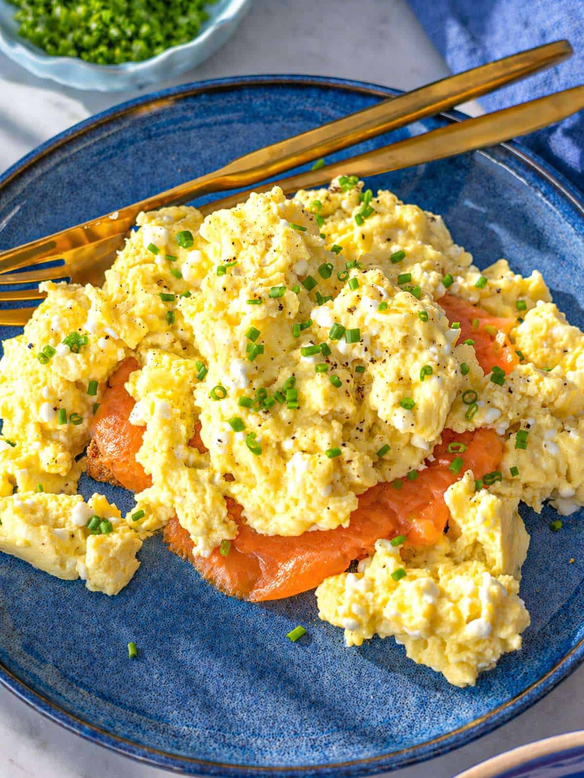 Soft cottage cheese eggs on toast with smoked salmon and fresh chives.